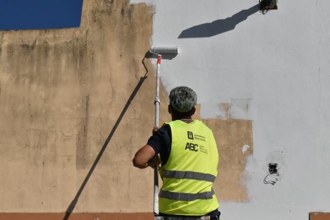 Un participante del programa ABC pintando una fachada